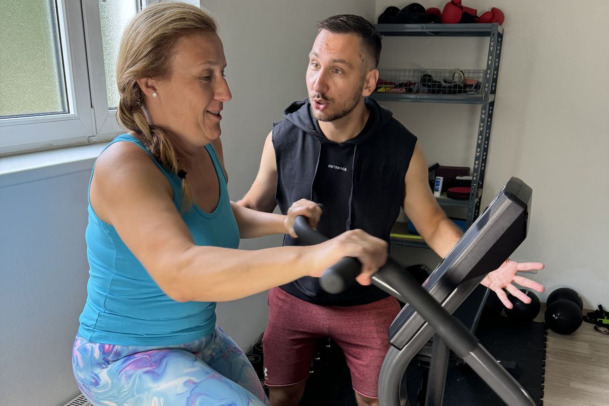 Klientka FitWay40 trénuje na kole pod vedením trenéra ve VT GYM
