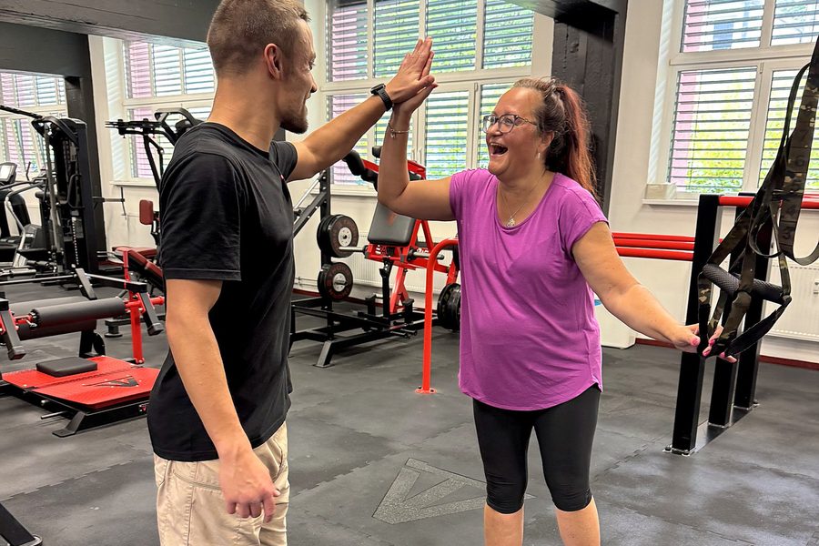 Klientka FitWay40 si po tréninku plácá s trenérem ve VT GYM
