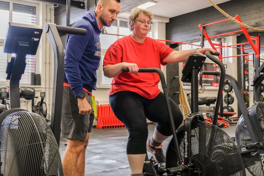 Klientka FitWay40 trénuje na airbiku pod dohledem trenéra