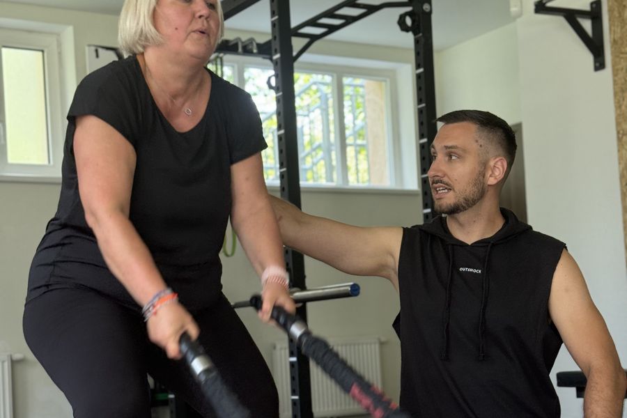 Klientka FitWay40 cvičí s trenérem na posílení zad ve VT GYM