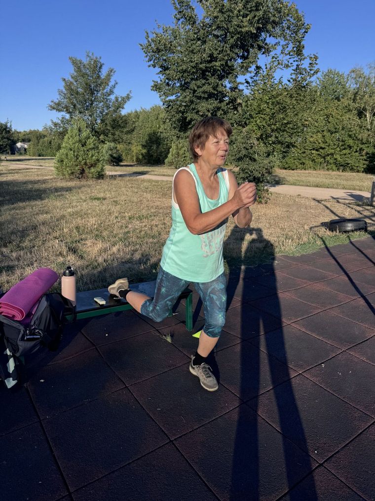 Trenér hlídá techniku klientce při cviku na workoutovém hřišti